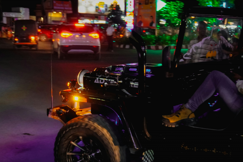 Modified UTV driving on a city street at night with bright lights and traffic
