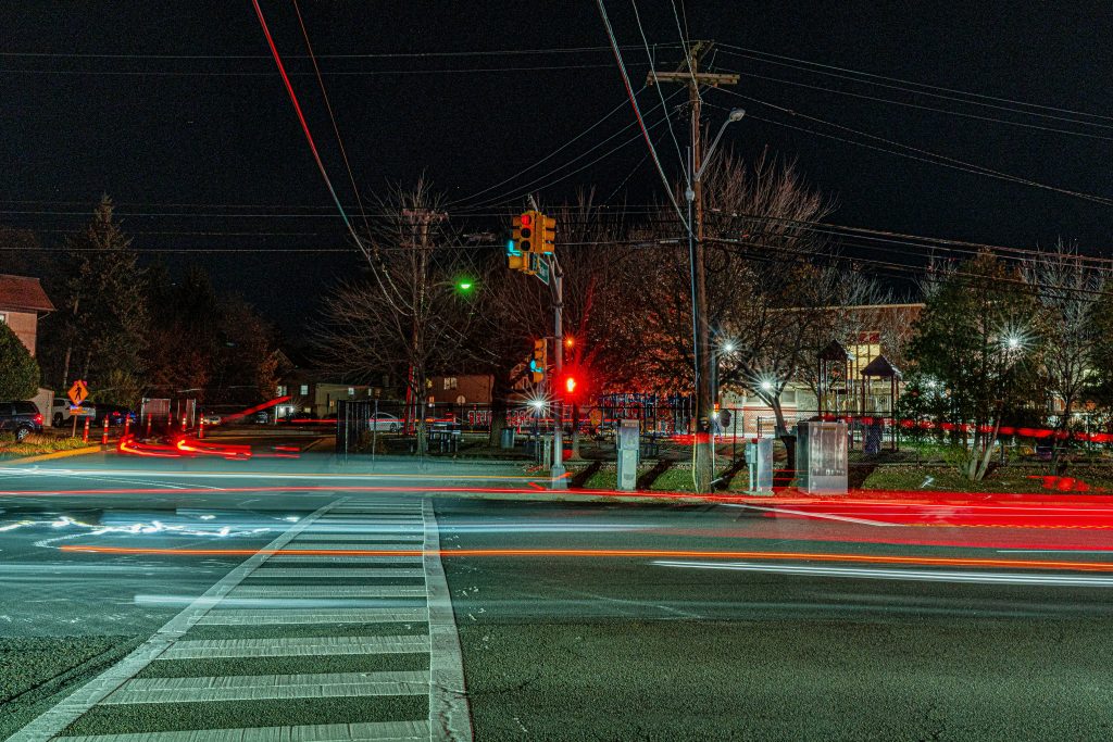 night intersection with traffic lights and car light trails showing right turn on red driving scenario