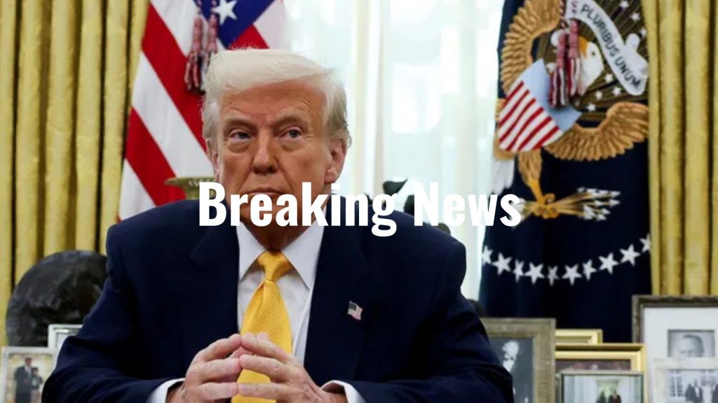 U.S. President Donald Trump sits at a desk in the Oval Office, framed by American flags and presidential insignia, with "Breaking News" text overlayed on the image.