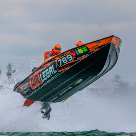 A high-speed Dirt Legal powerboat launches over the waves during a race, symbolizing the thrill of boating freedom and the advantages of Montana boat registration.