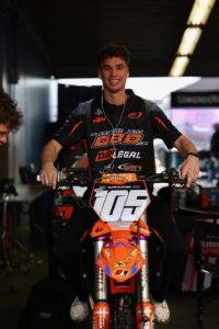 Marcus Phelps DBD Racing WMR KTM Team Portrait - Dirt Legal Marcus Phelps sitting on his race bike in the team pits wearing a Dirt Legal DBD Racing team shirt and headphones before the Daytona night show.