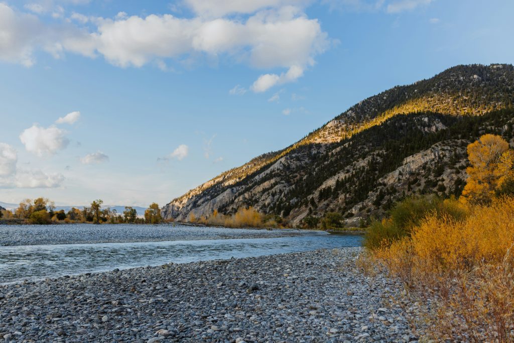 Montana river landscape with mountains and fall foliage, representing Montana vehicle sales tax advantages