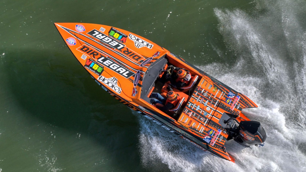 An overhead shot of the orange and black #789 Team Dirt Legal boat carving through the water during the New Orleans Powerboat Grand Prix.