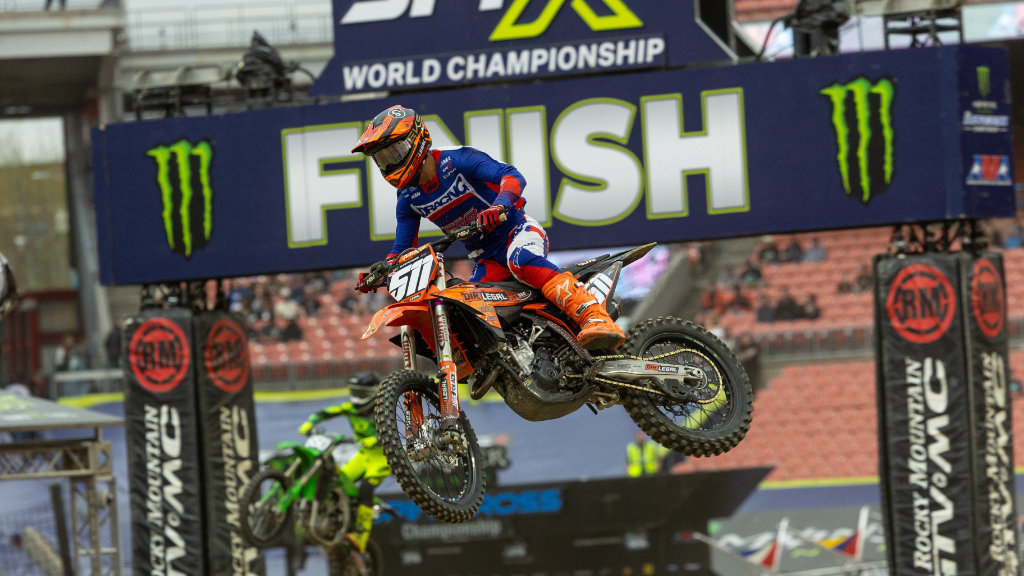 A side-view action shot of Jace Kessler on the #511 Dirt Legal DBDRacing KTM 250 dirt bike launching over a metal finish line structure at Huntington Bank Field during the Cleveland Supercross recap.