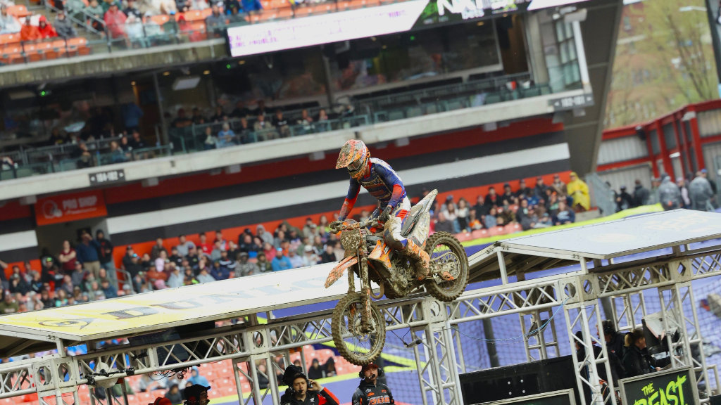 A head-on shot of Marcus Phelps #105 jumping his Dirt Legal KTM 250 SX-F past the finish line banner at Cleveland Supercross.