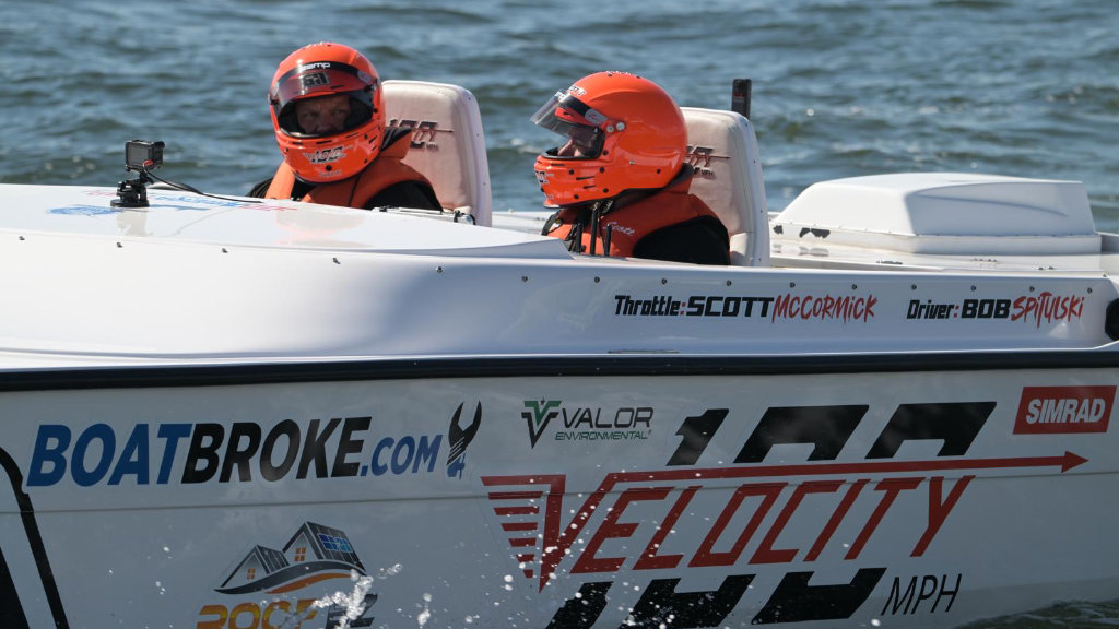 Driver Bob Spitulski and throttleman Scott McCormick wearing orange helmets inside the white #611 Ride Legal Velocity racing vessel.